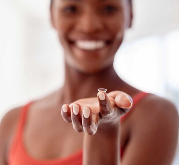 Black woman holding a contact lens on her finger