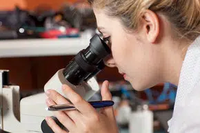 Female Researcher Looking In Microscope