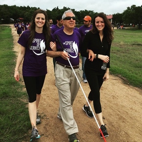 Amanda Eddy with her sister and father; the father is wearing sunglasses and carries a white cane