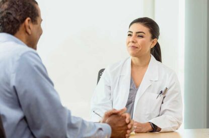 Male Patient Consults Woman Doctor In Her Office