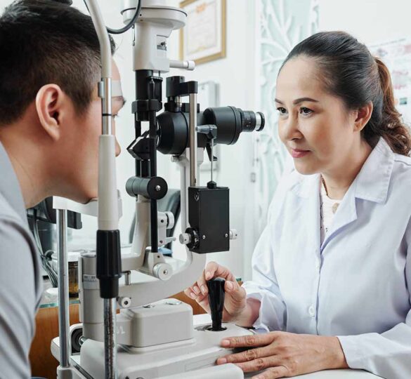A female ophthalmologist gives patient an eye exam in her office