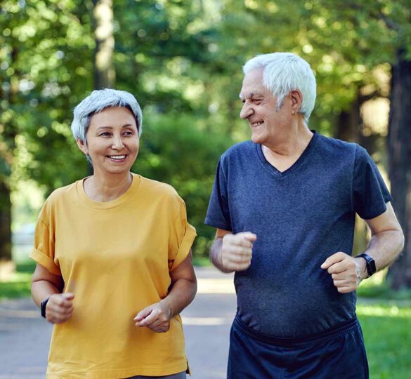 Senior couple jogging outdoors in a park