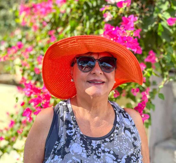 older Hispanic woman wearing sunglasses and a hat